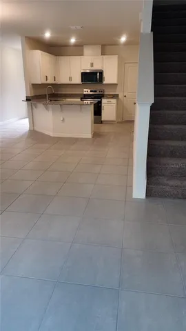 a view of kitchen with kitchen island white cabinets and stainless steel appliances