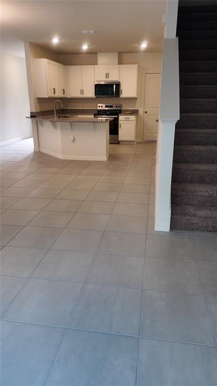 2798 Raindrop Run Street Clermont, FL 34714 - Photo 10 of 18 a view of kitchen with kitchen island white cabinets and stainless steel appliances