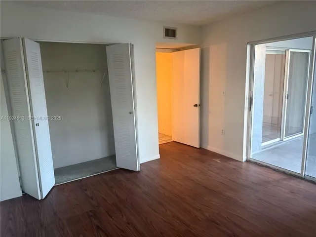 an empty room with wooden floor and door
