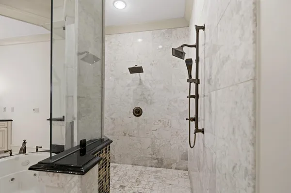 a spacious bathroom with a shower and a sink mirror