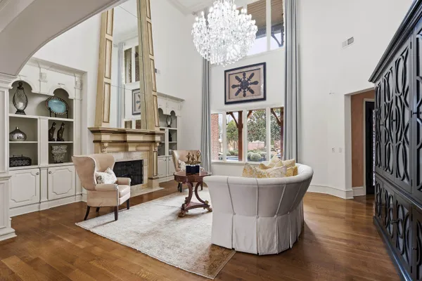 a living room with furniture a fireplace and a chandelier