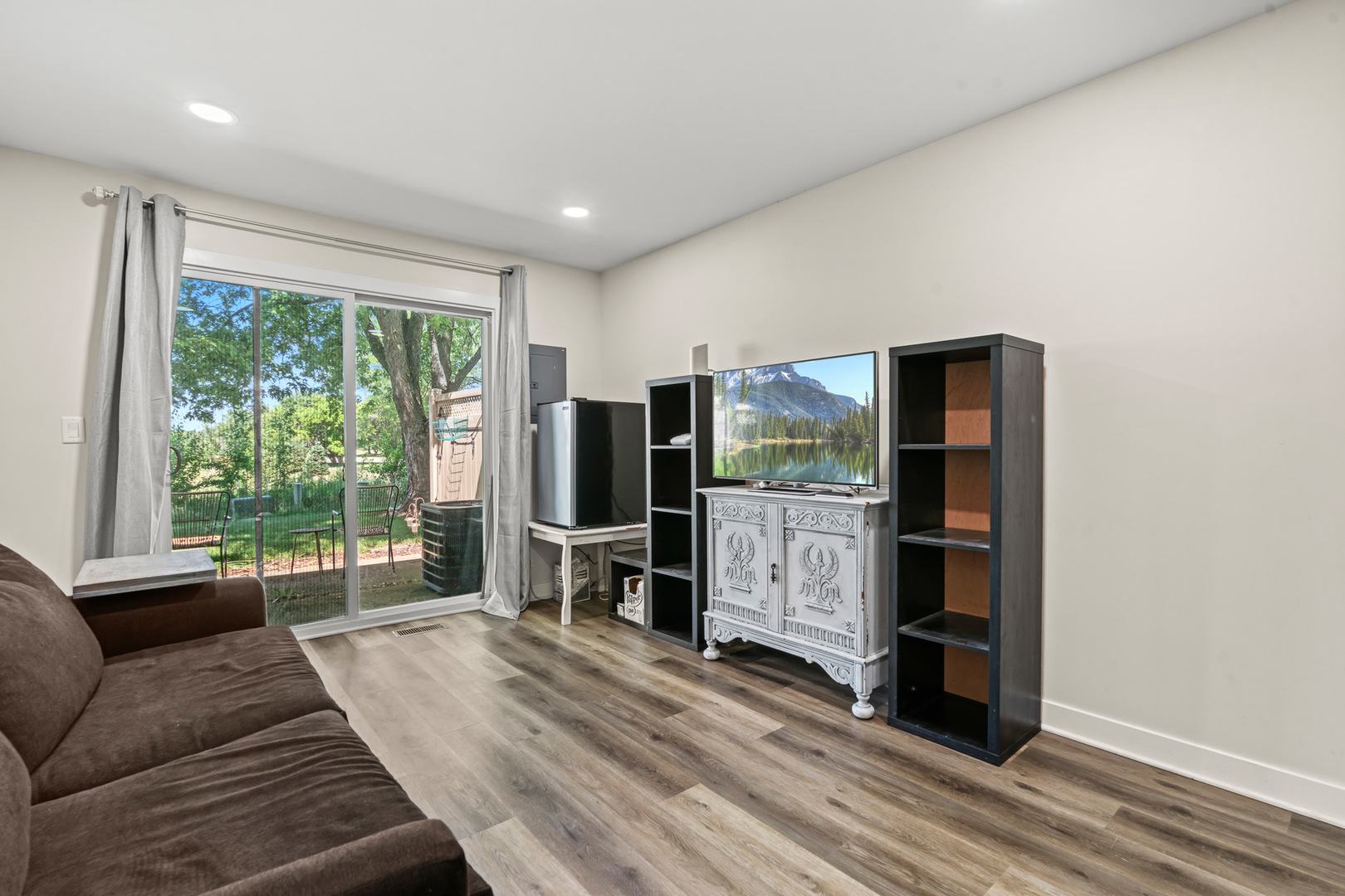 1598 Elder Drive Aurora, IL 60506 - Photo 16 of 22 a living room with furniture a flat screen tv and a floor to ceiling window