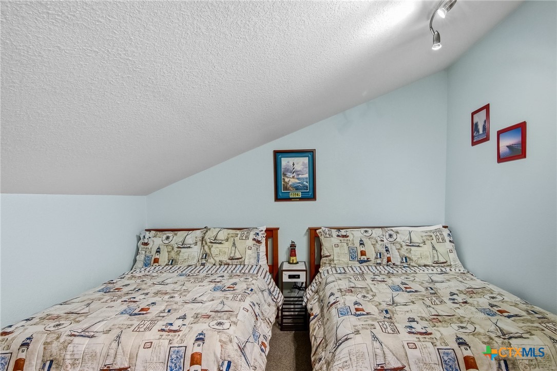 2292 North Fulton Beach Road, Unit 505 Rockport, TX 78382 - Photo 30 of 46 a bedroom with a large bed and a lamp