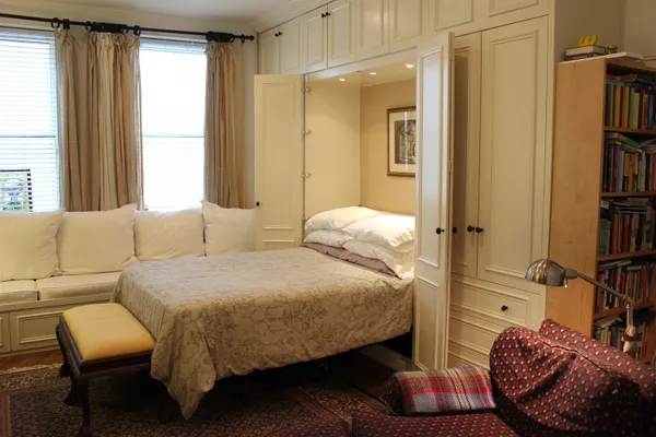 a bedroom with a bed couch and a window