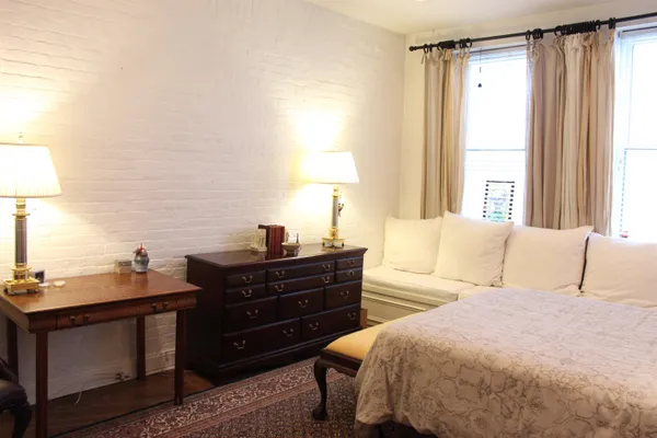 a bed room with a bed and a lamp on dresser