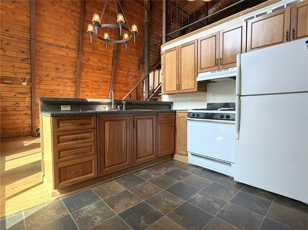 a kitchen with stainless steel appliances granite countertop a stove a refrigerator and a sink