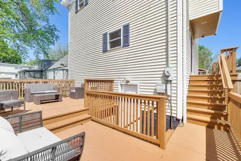 a view of a patio with couches table and chairs and wooden fence