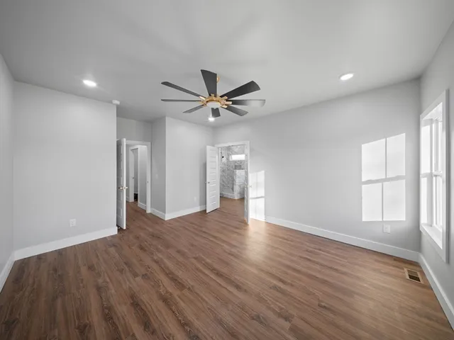 a view of a livingroom with a ceiling fan and wooden floor