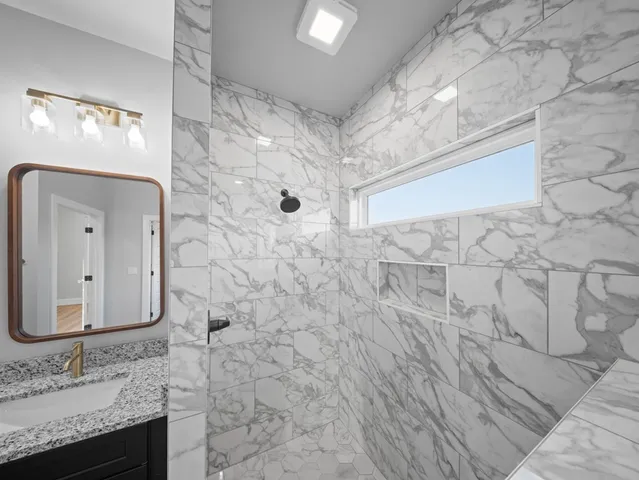 a bathroom with a granite countertop sink and a mirror