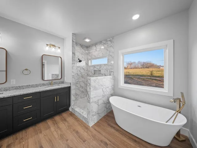 a spacious bathroom with a granite countertop tub sink and mirror