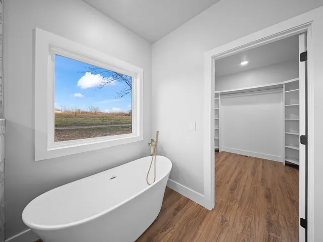 a bathroom with a bathtub and a window