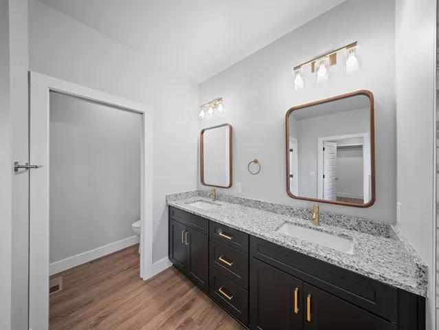 a bathroom with a granite countertop sink a large mirror and vanity