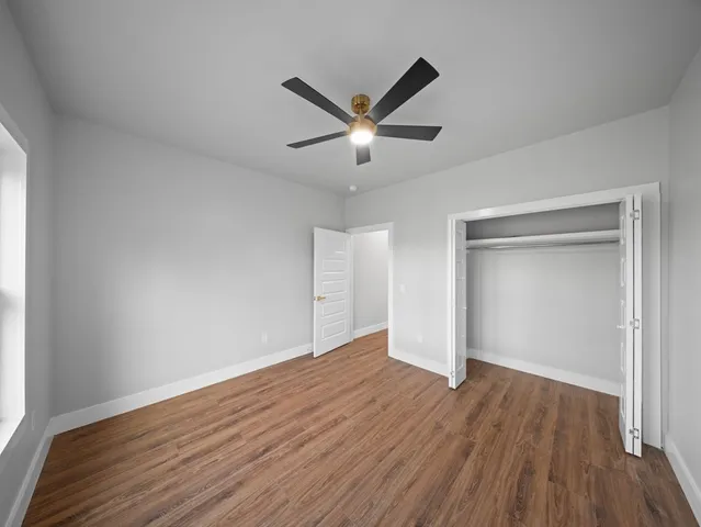 a view of a big room with wooden floor and a ceiling fan