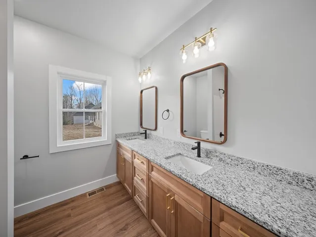 a bathroom with a double vanity sink and a mirror