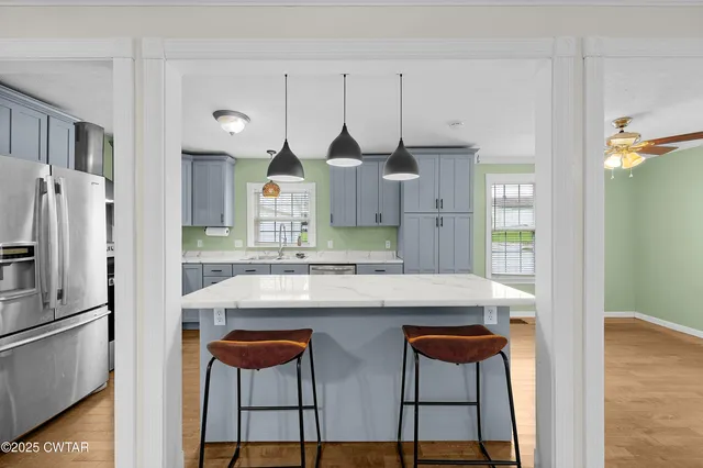 a kitchen with stainless steel appliances kitchen island granite countertop a refrigerator and a stove