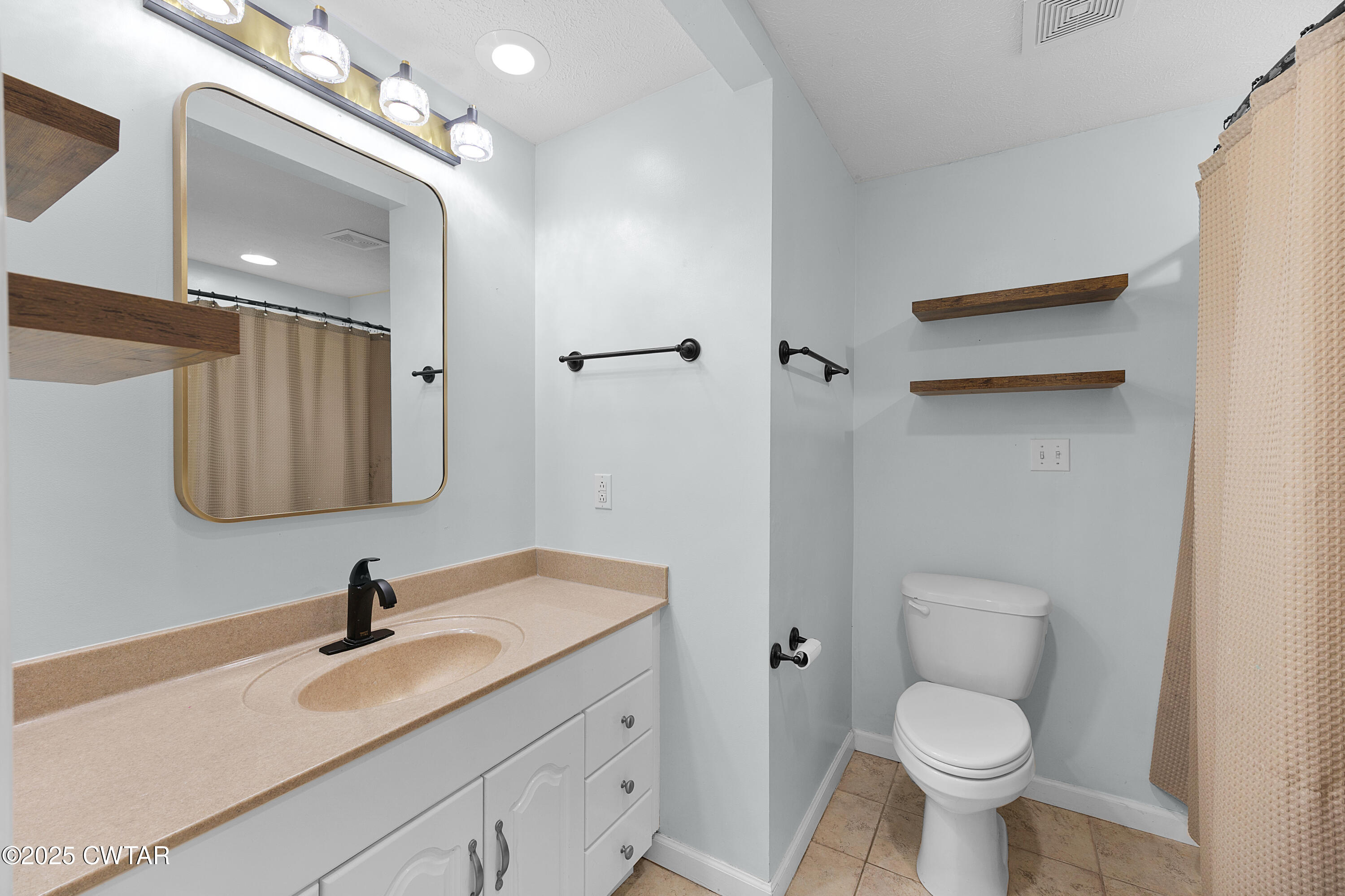 1675 Emerson Road Henderson, TN 38340 - Photo 18 of 21 a bathroom with a granite countertop sink toilet and mirror