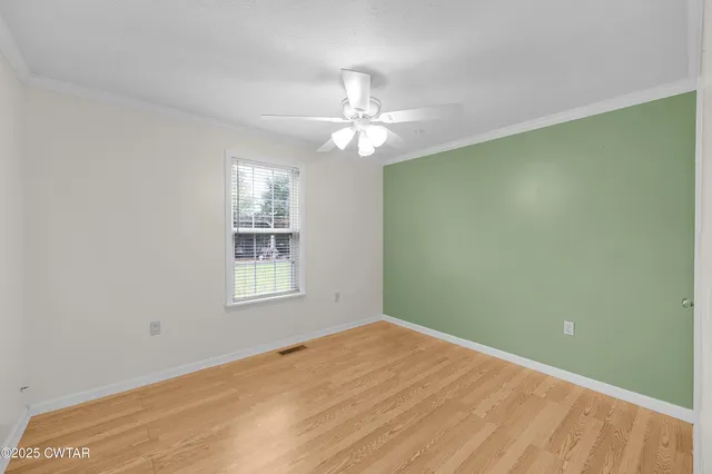 a view of a room with window a ceiling fan and wooden floor