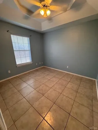 an empty room with windows and fan