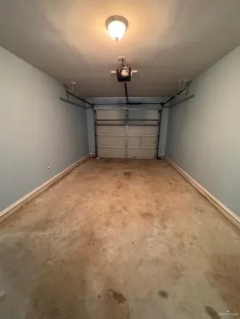 en empty room with stairs and chandelier