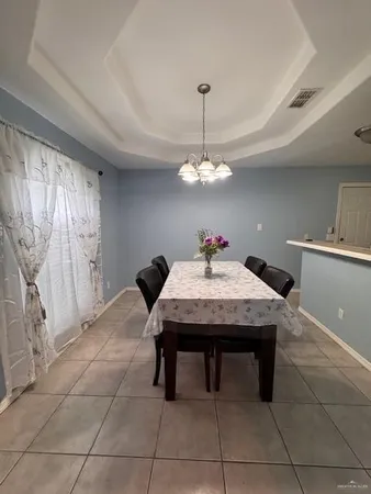 a room with a table chairs and chandelier