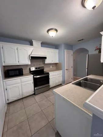 a kitchen with granite countertop a stove sink and cabinets