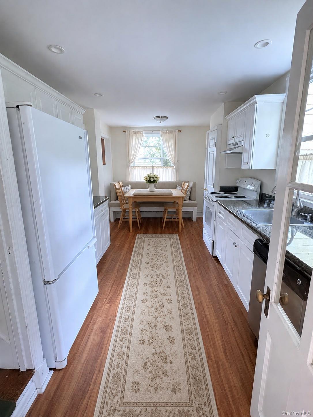 6 Tower Road Glen Cove, NY 11542 - Photo 4 of 12 a kitchen with a sink a refrigerator a stove and wooden floor