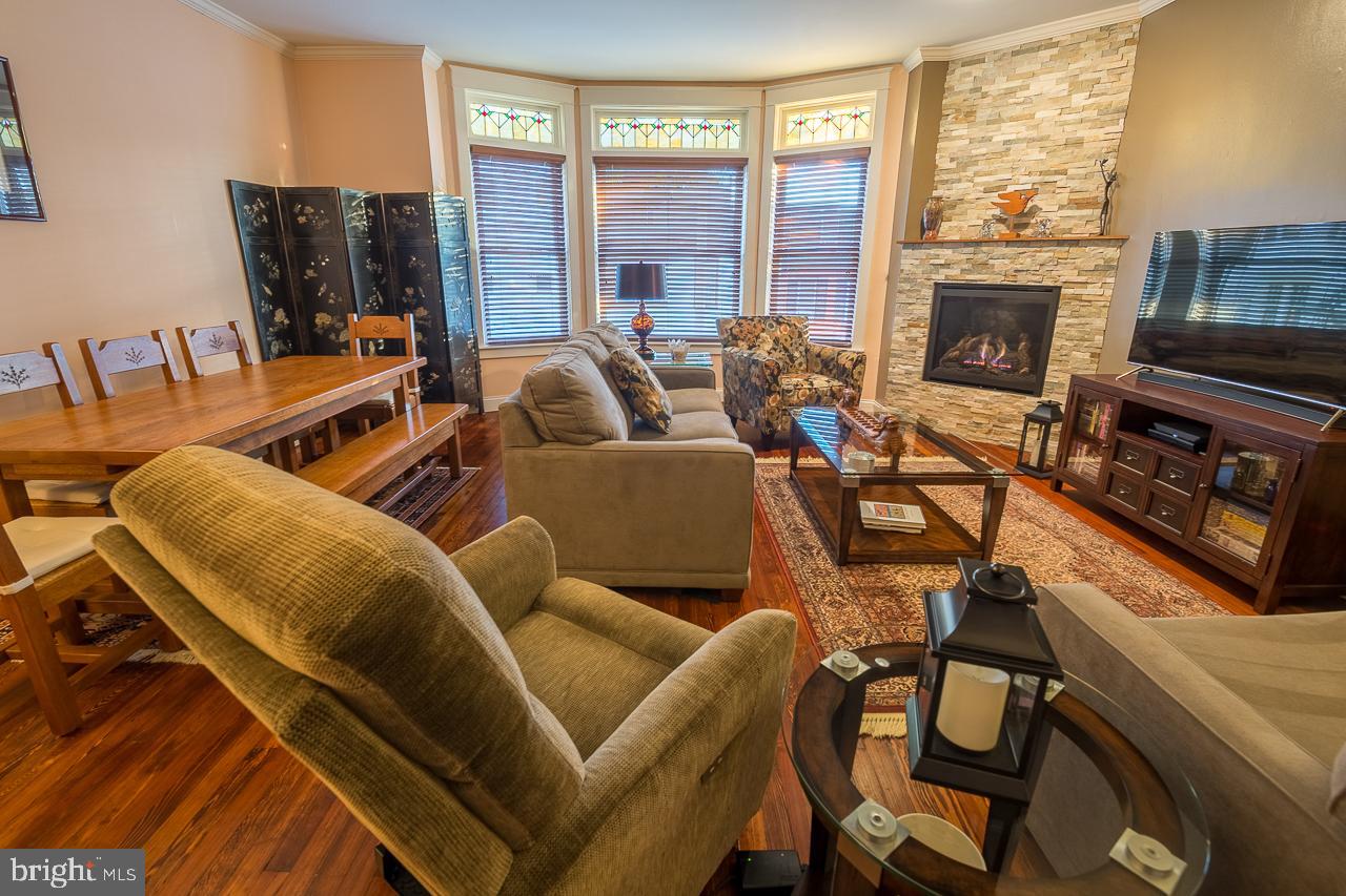 1043 Washington Street Reading, PA 19601 - Photo 2 of 40 a living room with furniture a fireplace and a floor to ceiling window