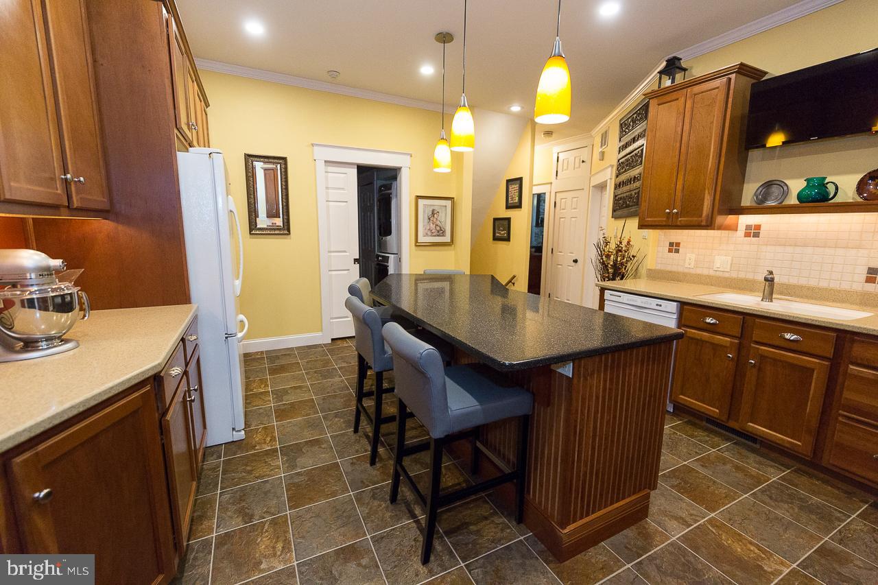 1043 Washington Street Reading, PA 19601 - Photo 8 of 40 a kitchen with stainless steel appliances granite countertop a sink a stove a oven a dining table and chairs