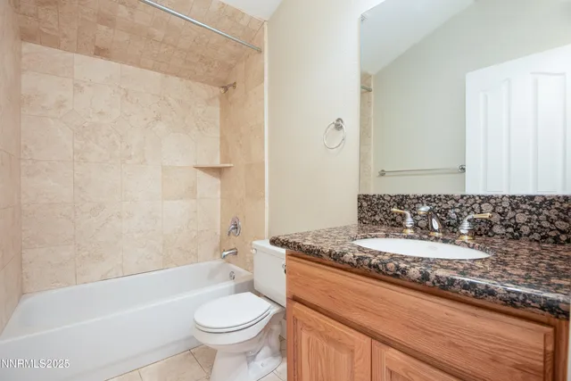 a bathroom with a granite countertop sink a toilet a mirror and a bathtub