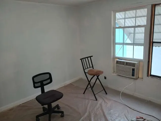 a view of a workspace with furniture and a window