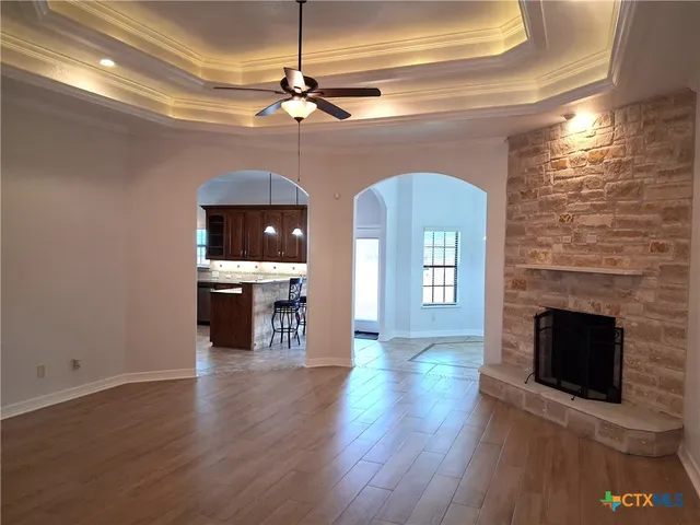 wooden floor fireplace and windows in an empty room
