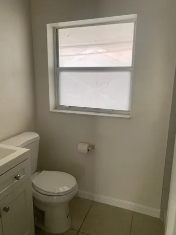a bathroom with a toilet a sink and a window