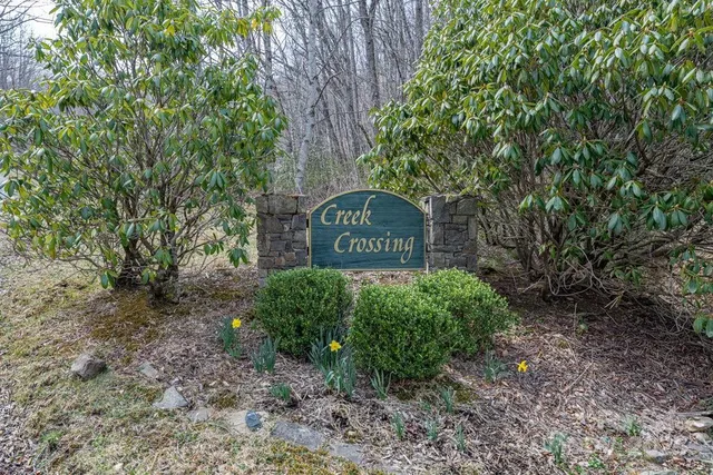 a sign that is sitting in front of a tree