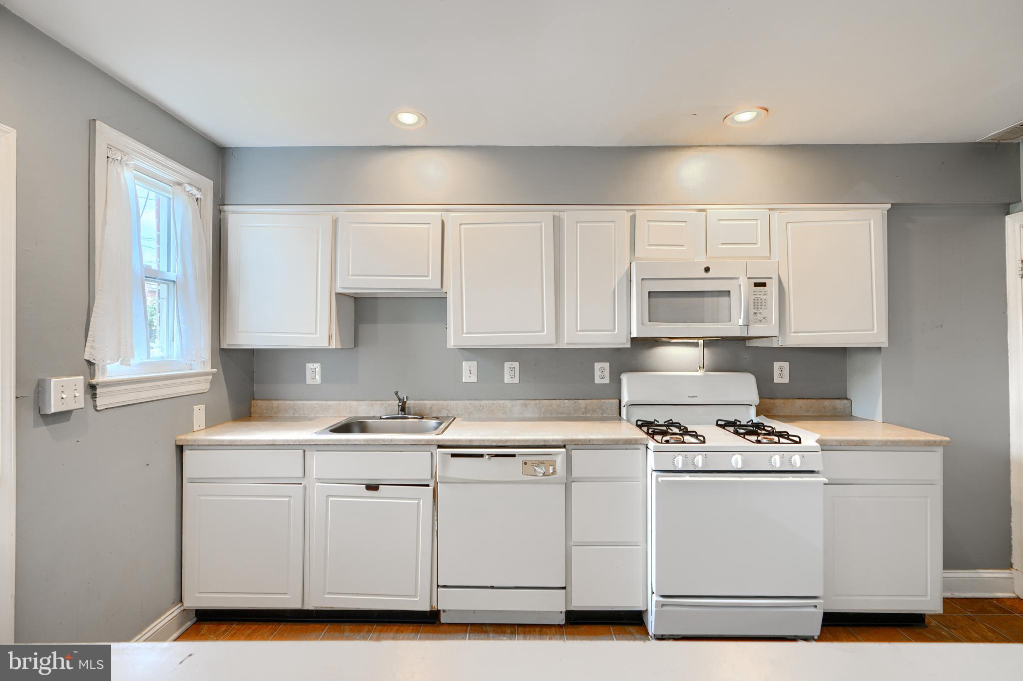 56 Yorkway Baltimore, MD 21222 - Photo 11 of 34 a kitchen with cabinets appliances a sink and a window