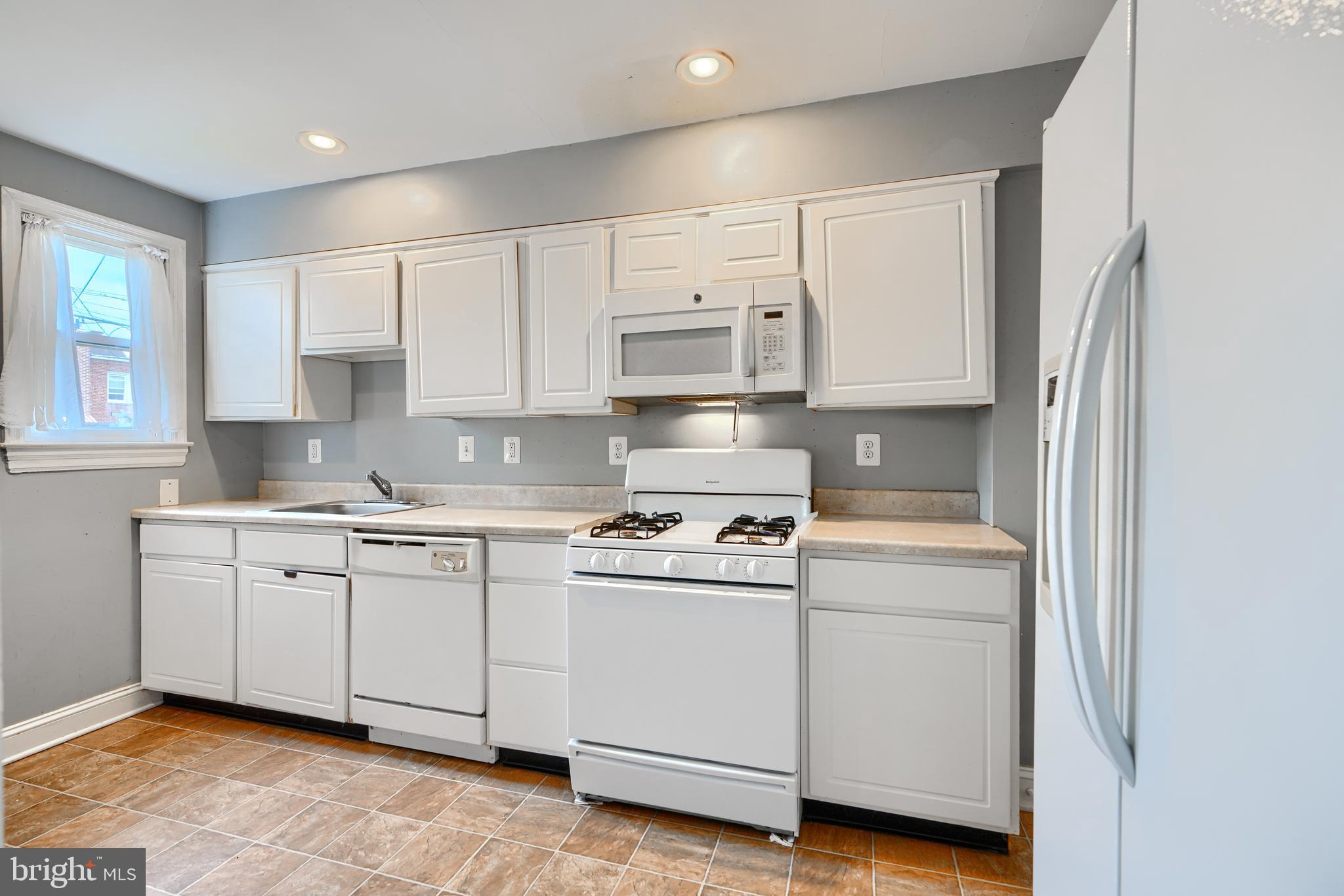 56 Yorkway Baltimore, MD 21222 - Photo 12 of 34 a kitchen with cabinets appliances a sink and a window