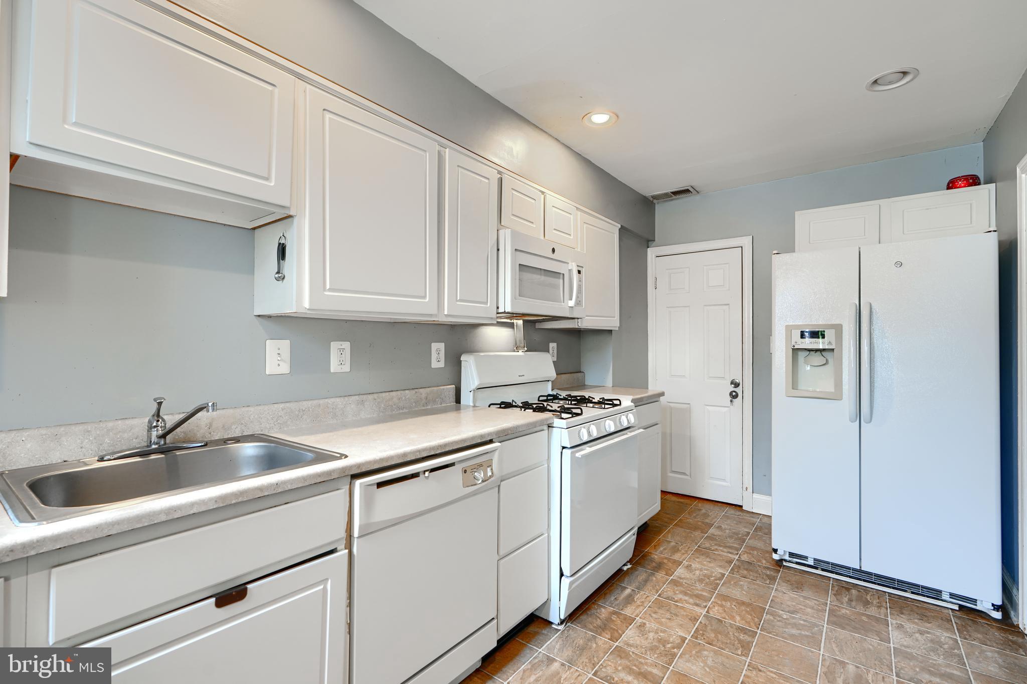 56 Yorkway Baltimore, MD 21222 - Photo 14 of 34 a kitchen with white cabinets and white appliances