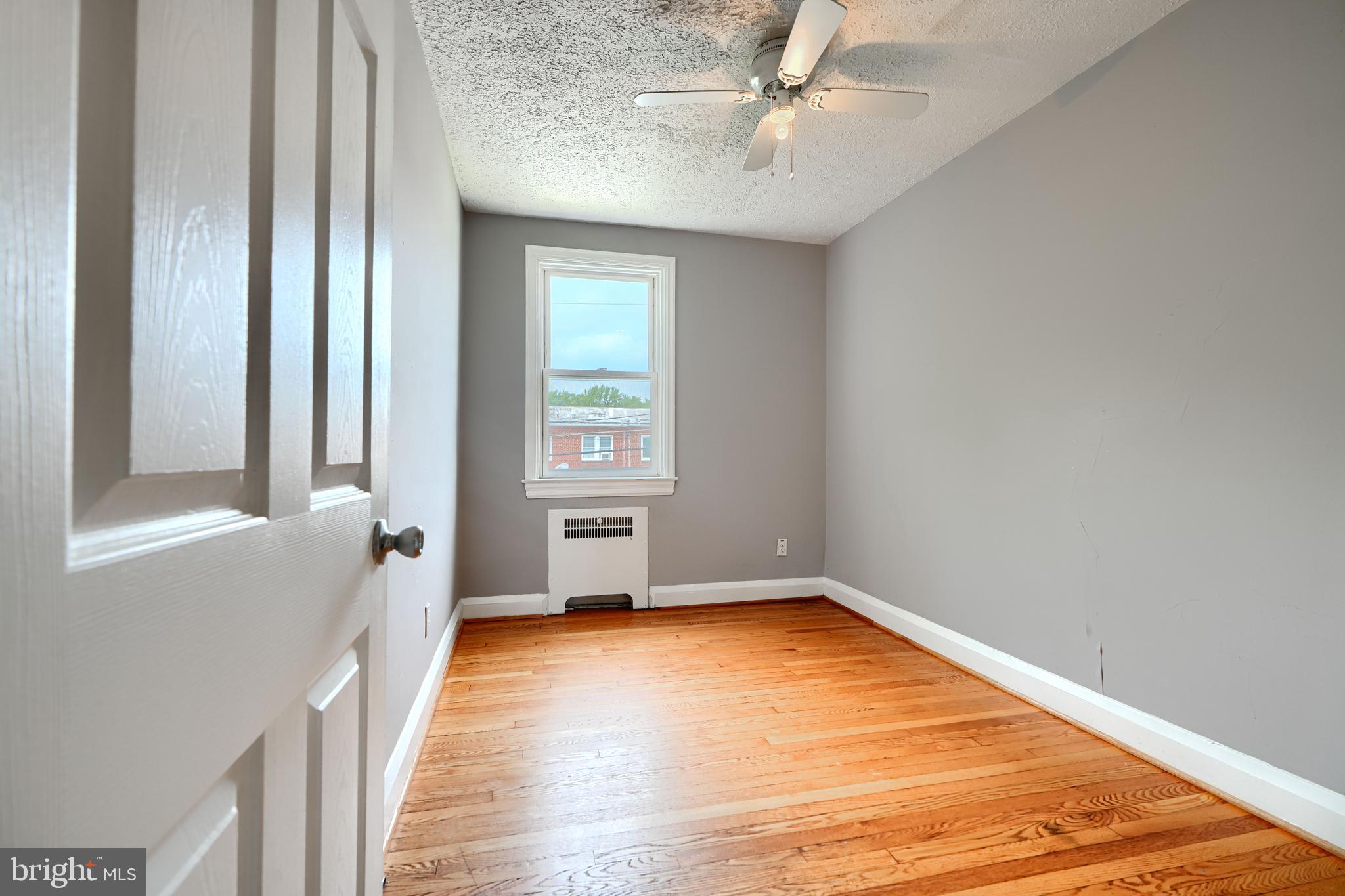 56 Yorkway Baltimore, MD 21222 - Photo 22 of 34 a view of an empty room with wooden floor and a window