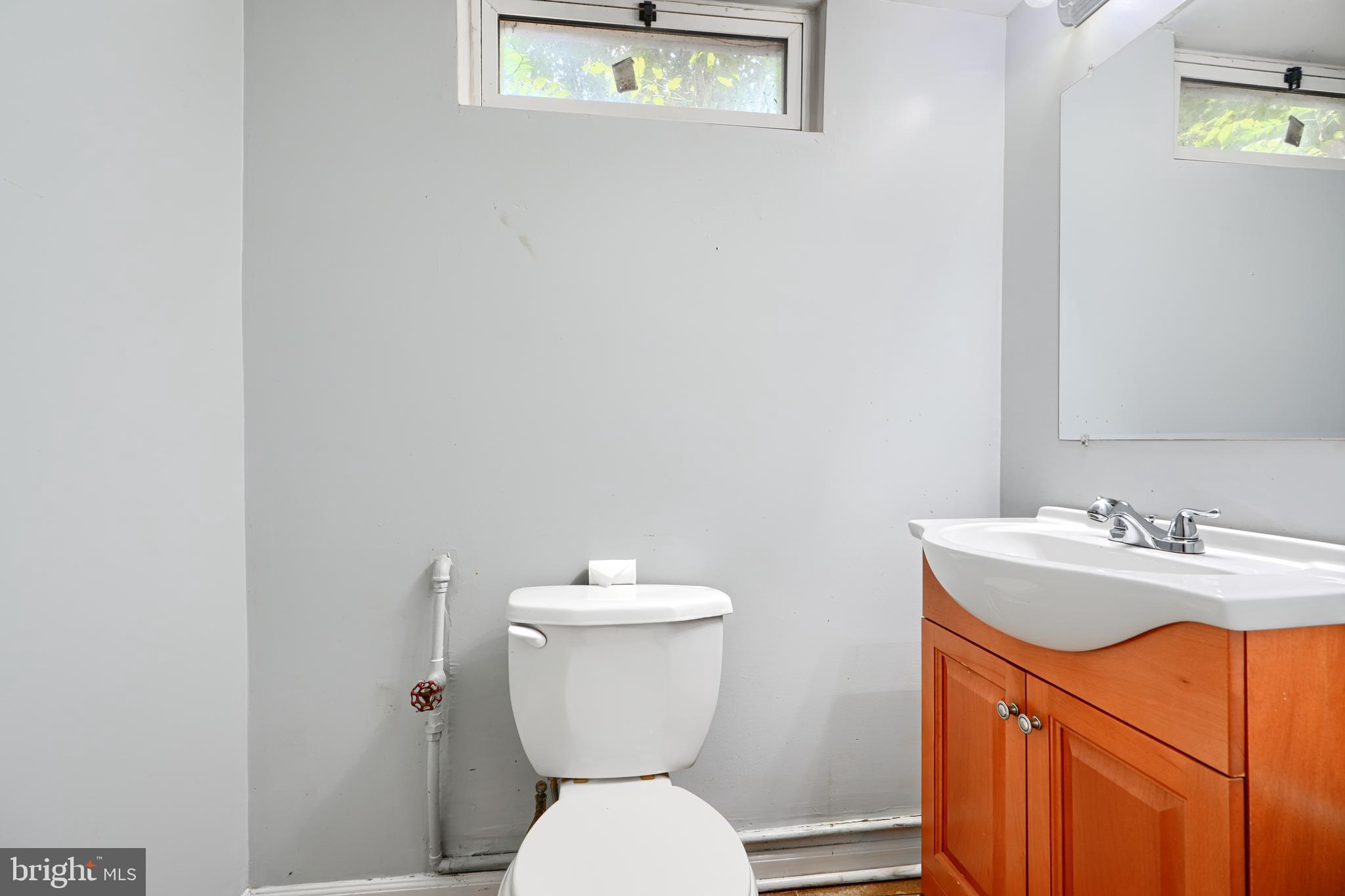 56 Yorkway Baltimore, MD 21222 - Photo 31 of 34 a bathroom with a toilet sink and mirror