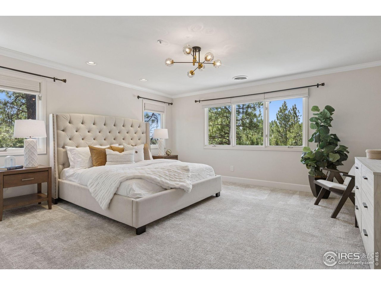 65 Indigo Way Castle Rock, CO 80108 - Photo 26 of 50 a bedroom with a large bed and a chandelier