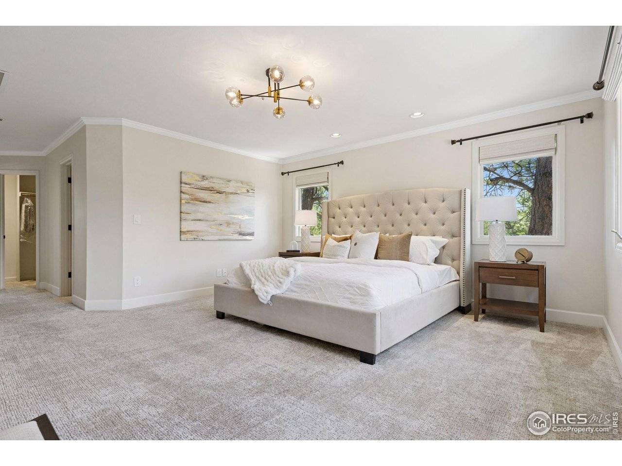 65 Indigo Way Castle Rock, CO 80108 - Photo 31 of 50 a bedroom with a large bed and a chandelier