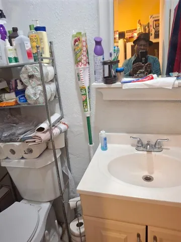 a bathroom with a sink mirror and toilet