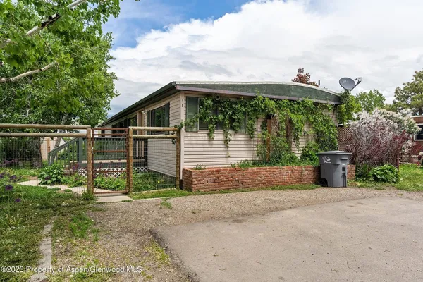 a view of a house in front of a yard with potted plants