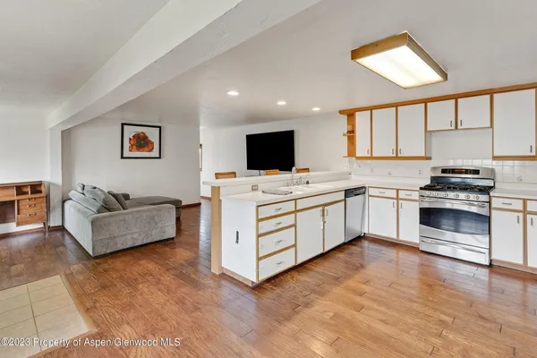a kitchen with stainless steel appliances a stove top oven and a refrigerator