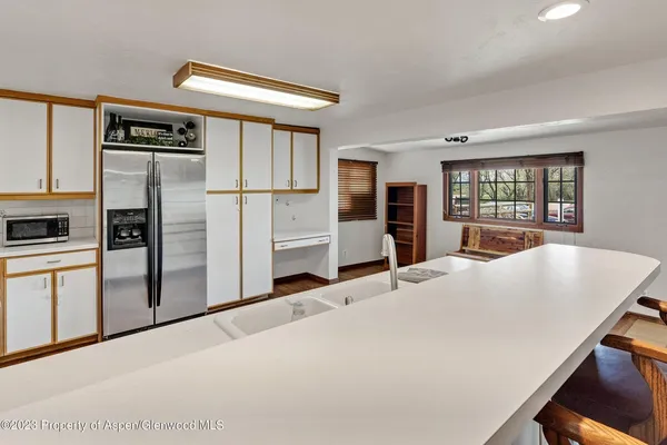 a kitchen with granite countertop a refrigerator and a stove top oven