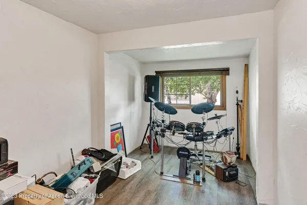 a room with gym equipment and wooden floor