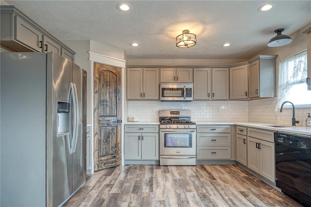 131 Rylie Drive Harmony, PA 16037 - Photo 7 of 34 a kitchen with kitchen island granite countertop appliances cabinets and a sink
