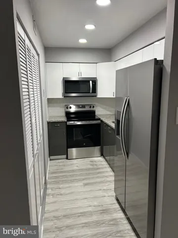a kitchen with stainless steel appliances a refrigerator and a stove top oven