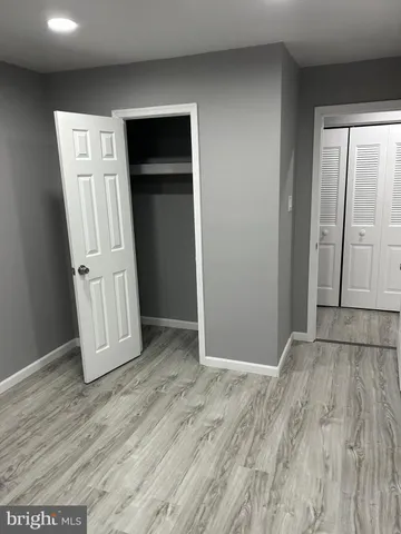 an empty room with wooden floor and closet