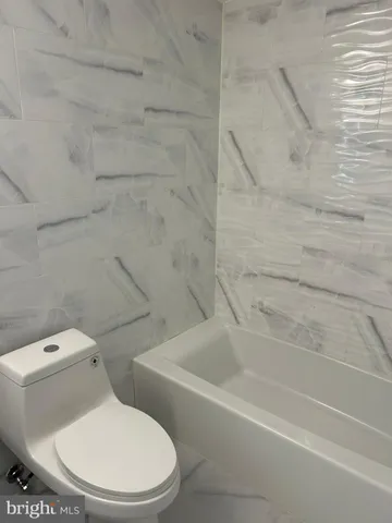 a white toilet and tub sitting next to a bathroom sink