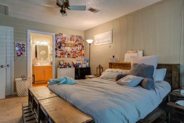 a bedroom with a bed a couch and a chandelier